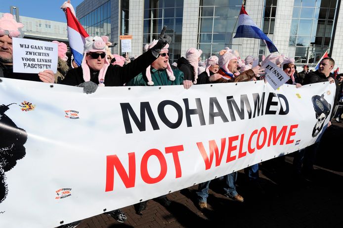 Demonstranten van de anti-islambeweging Pegida protesteren in september vorig jaar met een varkensmasker voor het stadhuis in Amsterdam tegen het vluchtelingenbeleid