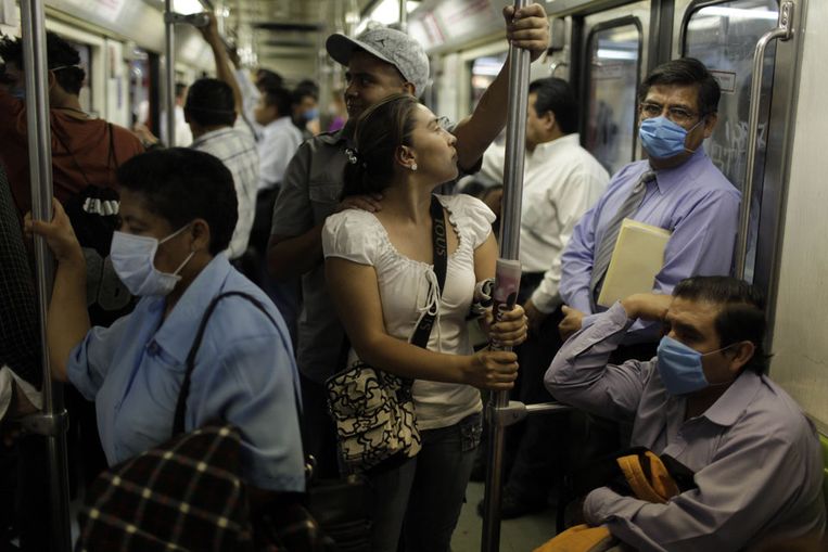 Forenzen in Mexico-Stad dragen monddoekjes. In Mexico zijn waarschijnlijk 152 mensen overleden als gevolg van de varkensgriep, aldus minister CÃ³rdova van Volksgezondheid. (AP) Beeld 