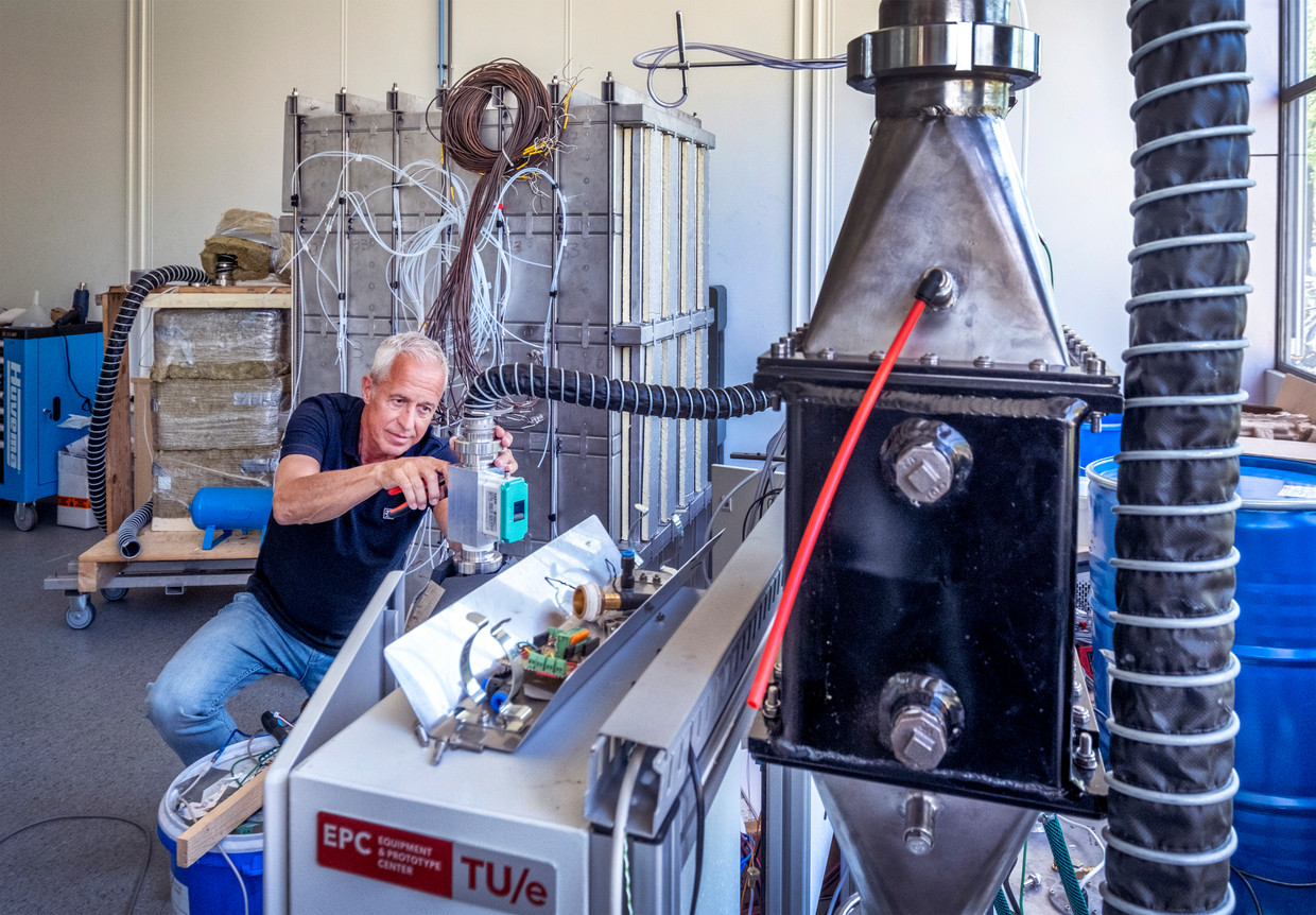 Hoogleraar Olaf Adan aan het werk met een enorme warmtebatterij (zilver achtergrond) gebaseerd op zout.  Beeld ©raymond rutting photography