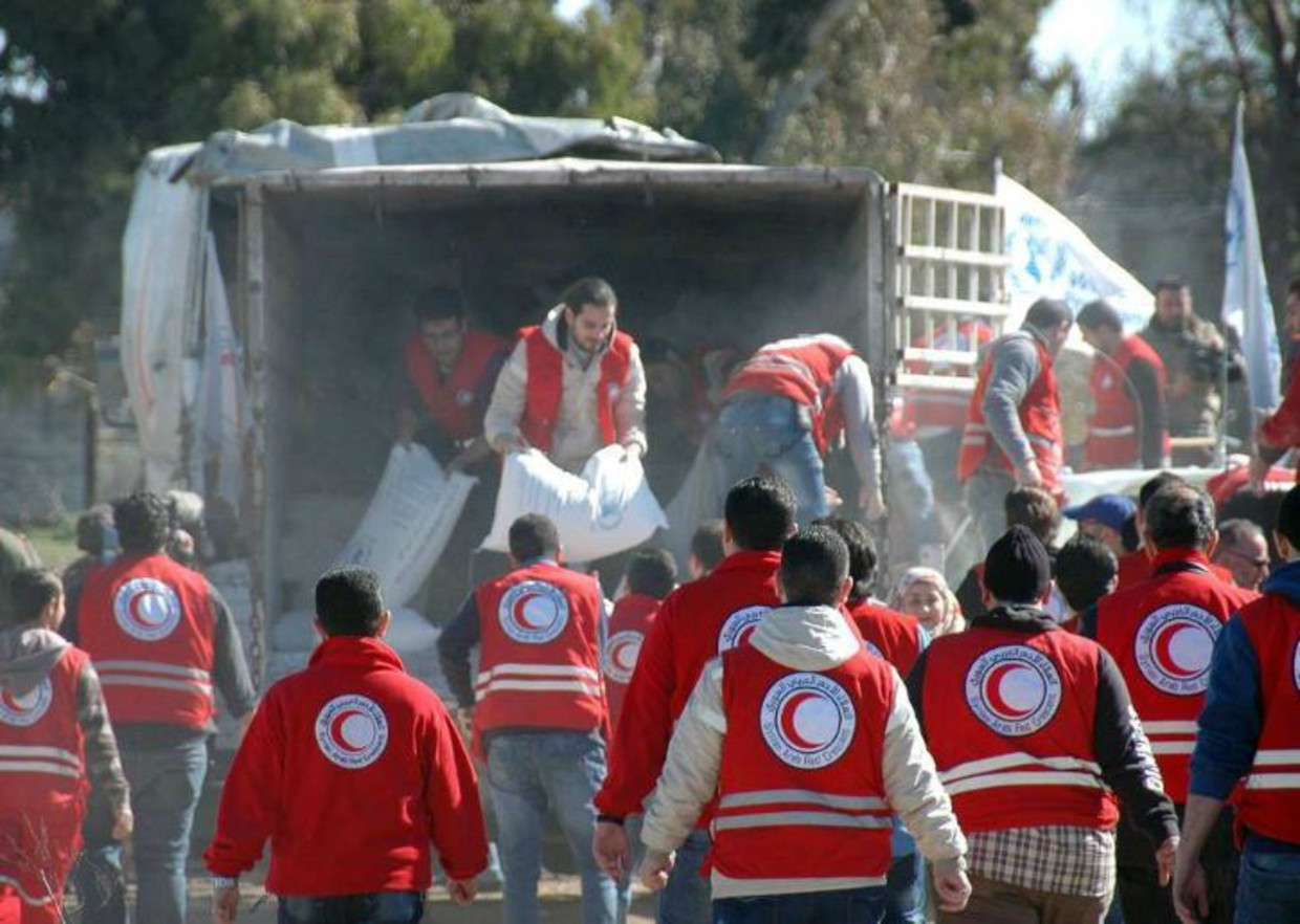 Hulpverleners bezorgen goederen bij de evacués uit Homs. Beeld afp