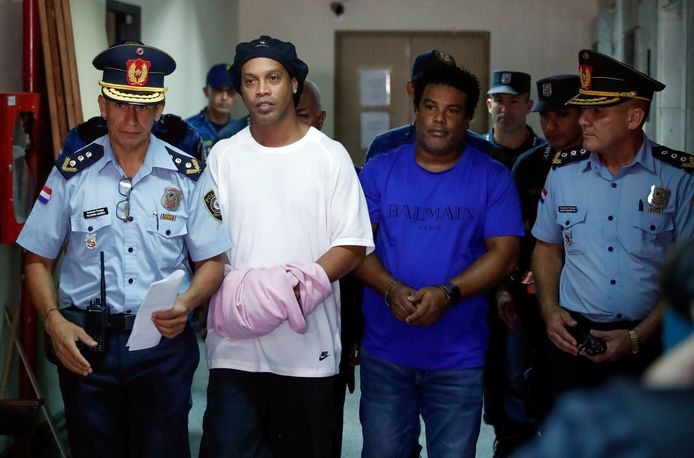 Ronaldinho - handboeien netjes bedekt onder een handdoek - en zijn broer begeleid door de Paraguayaanse politie.
