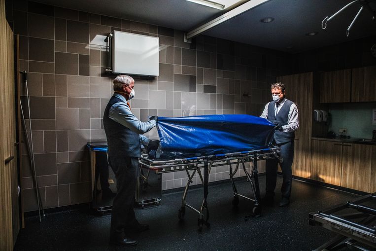 April 2020, uitvaartverzorgers in Den Bosch ontfermen zich over een overledene.  Beeld Aurélie Geurts