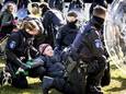 Een klimaatactivist van Extinction Rebellion wordt aangehouden tijdens een actie bij Eindhoven Airport.