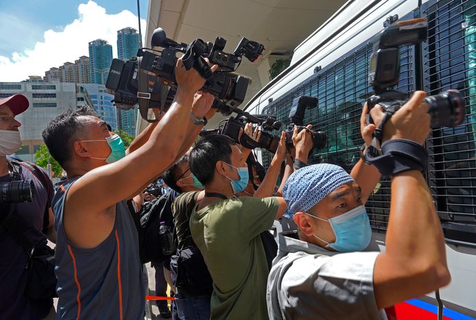 Fotografen omringen het busje waarin Tong Ying-kit vervoerd wordt.