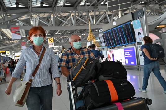 Reizigers met mondmaskers in Bangkok.