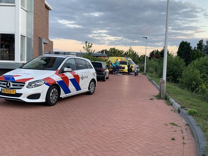 Ambulancepersoneel verleent eerste hulp aan de vrouw.