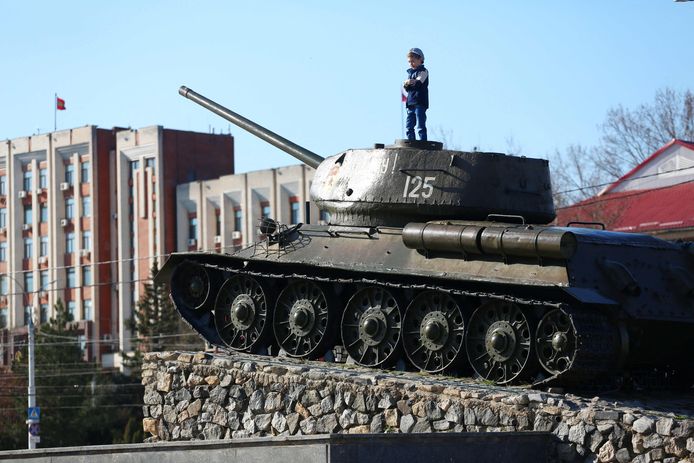 Een kind poseert op een oude tank in Tiraspol, de hoofdstad van Transnistrië.