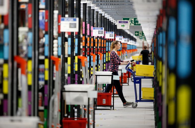 Een ‘orderpicker’ verzamelt producten uit de schappen van een vestiging van Amazon ten noorden van Londen. Beeld AFP