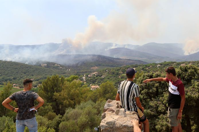 La gente guarda gli incendi boschivi a Cogolin (L) e Val de Gilly (R) di Grimaud.