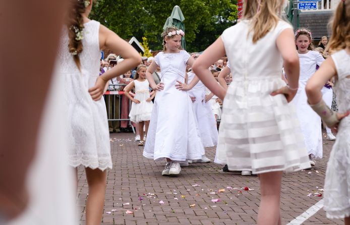 Twee jaar kon niet, maar dit jaar zongen en dansten de Pinksterbruidjes eindelijk weer in onder de kleurrijke Pinksterkroon op het Dorsetplein.