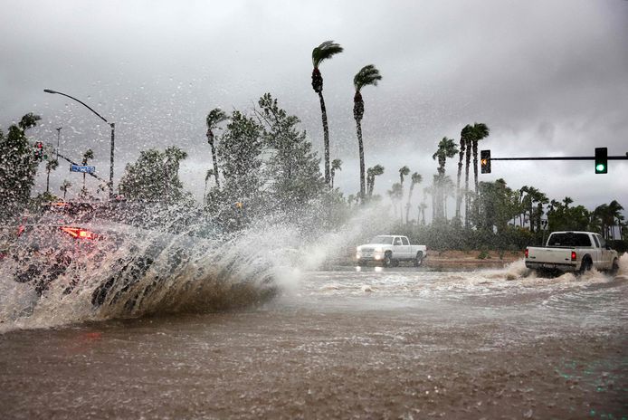 Auto's rijden door een overstroomde straat in Cathedral City, Californië.