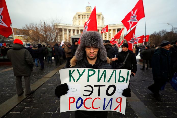 Russische betoger houdt een bordje vast met “De Koerilen-eilanden zijn Rusland”.