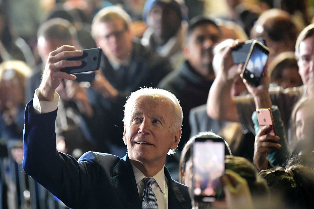 De Democratische presidentskandidaat Joe Biden neemt een selfie met zijn aanhangers. Beeld AFP