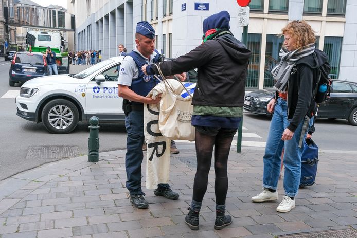 Een spandoek van de demonstranten wordt in beslag genomen.