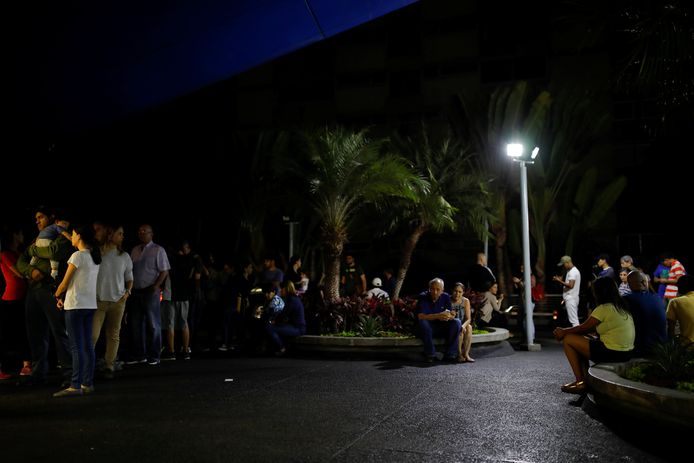 mensen schuiven aan voor de ingang van een apotheek tijdens de blackout in de Venezolaanse hoofdstad Caracas.