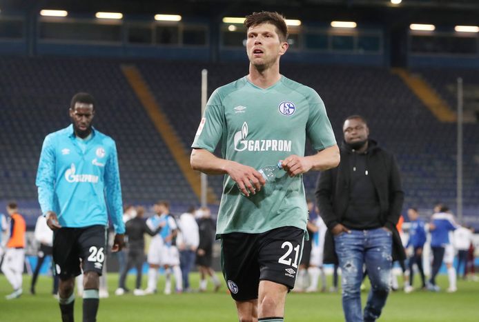 Klaas-Jan Huntelaar verlaat ontgoocheld het veld in Bielefeld nadat Schalke is gedegradeerd. Rechts: teammanager Gerald Asamoah.