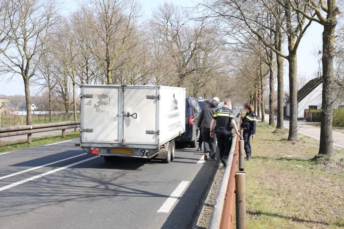 Op de N324 bij Reek is een auto achterop een bestelbus met aanhanger gereden.
