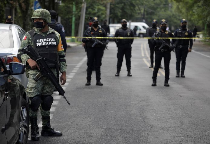 Een soldaat en politieagenten op de plaats in Mexico City waar een aanslag werd gepleegd op het hoofd van de veiligheidsdienst.