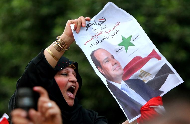 Een aanhanger van Al Sisi zwaait met zijn poster. Beeld afp
