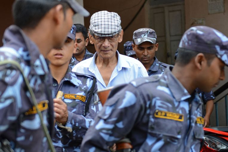 Charles Sobhraj (midden) wordt in 2014 door de Nepalese politie geëscorteerd naar de rechtszaal. De seriemoordenaar, op wie de succesvolle Netflix-serie 'The Serpent' is gebaseerd, komt binnenkort om gezondheidsredenen vrij. Beeld AFP