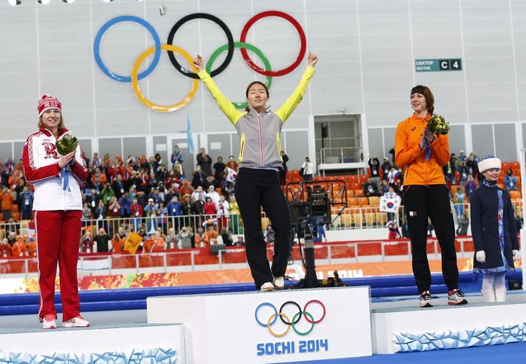 Sang-Hwa Lee bestijgt het podium na het winnen van de 500 meter, Margot Boer (brons, rechts) kijkt toe Beeld epa