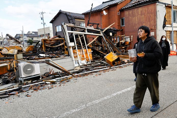 Een man zoekt naar zijn kat tussen de beschadigde huizen.