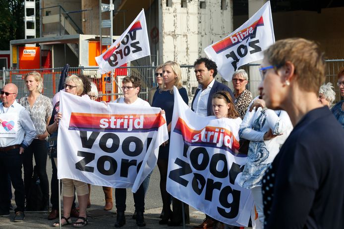 Bestuurder Eliane Thewessen (voorgrond) luistert naar toespraken, op de achtergrond de Kamerleden Marijnissen en Özdil temidden van spandoeken ‘Strijd voor de zorg’.