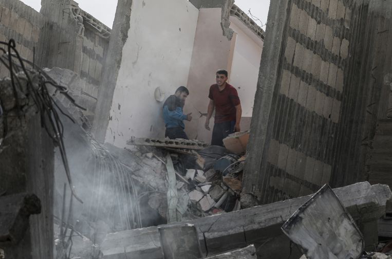 Inwoners van Gaza bekijken de puinhopen van een huis dat is verwoest door een luchtaanval van Israël op 6 mei.  Beeld EPA