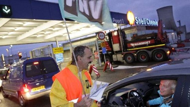 FNV-leden bijten het spits af in Moerdijk op de FNV-actiedag. Zij roepen werknemers van Shell bij de poort van hun bedrijf op in de middag het werk 65 minuten stil te leggen. ( ANP) Beeld 