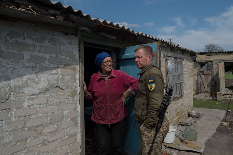 Andrii Bystrik praat met een van de laatst overgebleven dorpbewoners. Lydia Ivahivna's kleinzoon werd doodgeschoten door Russische soldaten.  Beeld Vincent Haiges