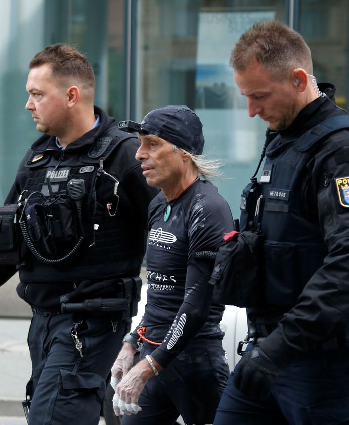 Alain Robert wordt afgevoerd door twee Duitse politieagenten.