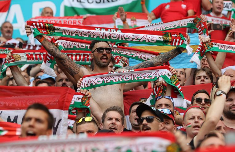 Hongaarse fans moedigen het nationaal elftal aan in Boedapest. In Hongarije gelden al langer nog amper maatregels tegen het coronavirus.  Beeld Pool via REUTERS