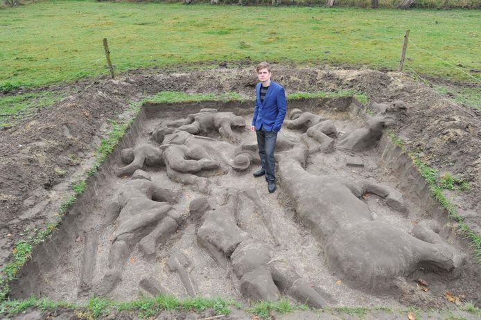 Rob Buelens bij zijn moddersculptuur ' No Man's Land ' in zijn tuin in Londerzeel. Daarvan wil hij volgend jaar een grotere versie maken in Ieper. Om daarvoor geld in te zamelen, verkoopt hij kleine oorlogstaferelen uit klei (inzet boven).