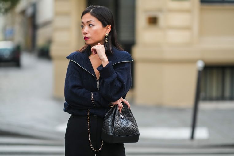 PARIS, FRANCE - NOVEMBER 08: May Berthelot wears Chanel pearl / logo earrings, a blue ribbed pullover with large collar and front zipper opening, a black leather quilted Chanel backpack bag, on November 08, 2021 in Paris, France. (Photo by Edward Berthelot/Getty Images) Beeld Getty Images