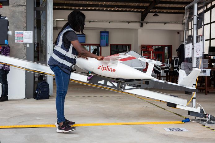 Een medewerker laadt een drone voor een levering in Ghana.