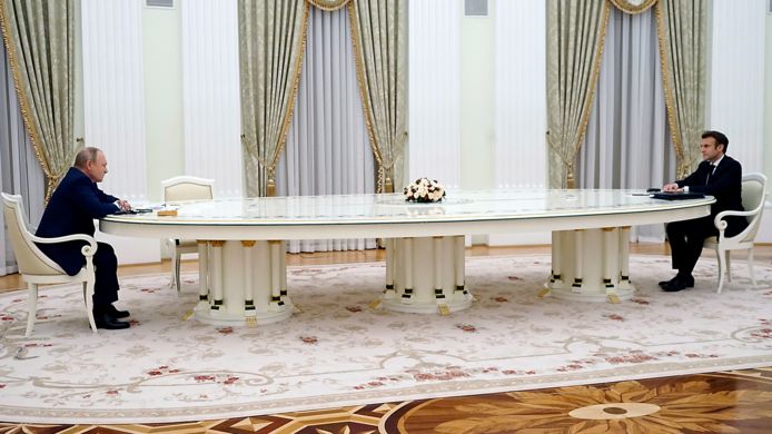 Een meterslange tafel, met de Russische president Poetin aan de ene kant en zijn Franse collega Macron aan de andere kant.