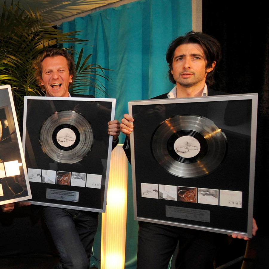 Mauro Pawlowski, Tom Barman (links) en de rest van dEUS ontvingen in 2008 een platina plaat voor het album 'Vantage Point'.