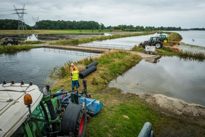 Drie grote machines pompen de uiterwaarden bij gemaal Hoenwaard bij Hattem leeg, na de dijkdoorbraak in juli.