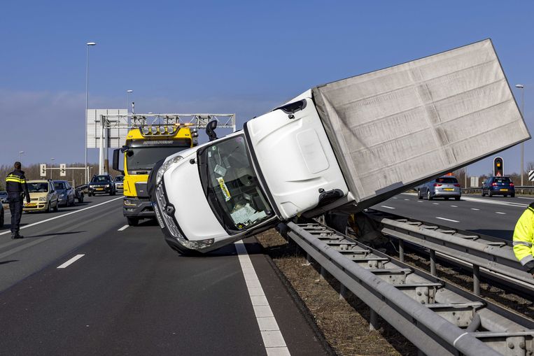 Een vrachtwagen is omgewaaid op de A9 bij knooppunt Rottepolderplein, door de wind. Beeld ANP