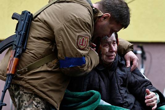 Een man knuffelt zijn 82-jarige moeder bij de evacuatie in Irpin.