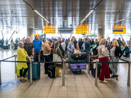 Drukte op Schiphol 'behapbaar', wachtende reizigers gepaaid met stroopwafels