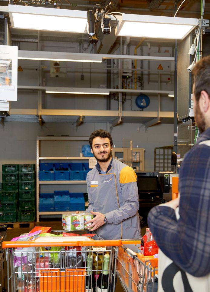 Boven de kassa's in de Colruyt in Halle hangt een camera met artificiële intelligentie die de producten automatisch scant wanneer deze overgezet worden van de ene kar naar de andere.