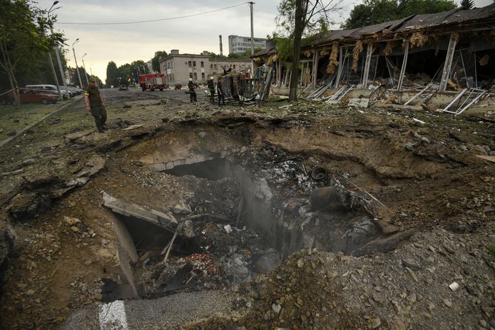 Mensen staan bij een krater in Dnipro die het gevolg is van een Russische raketaanval. (16/07/22)