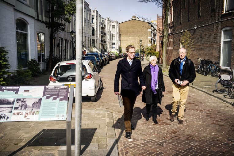 De Haagse Jacob Obrechtstraat met informatiebord van de wandelroute en initiatiefnemers (van links af) Marc Scheidius, Gesien Bruins en Jan Goossensen. Beeld Jiri Buller