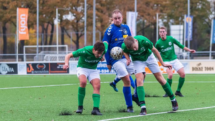 Dailey Jongedijk zit klem tussen twee spelers van Berghuizen. Hij kon zich de hele middag niet ontworstelen aan de verdedigers in het groen en wit.