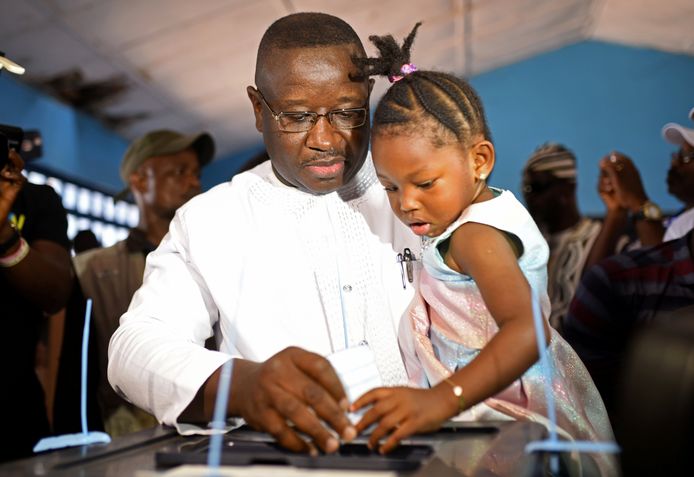 Julius Maada Bio brengt met zijn dochtertje op de arm zijn stem uit.  Hij kreeg 51,81 procent van de stemmen achter zich, tegenover 48,16 procent voor regeringskandidaat Samura Kamara van de APC