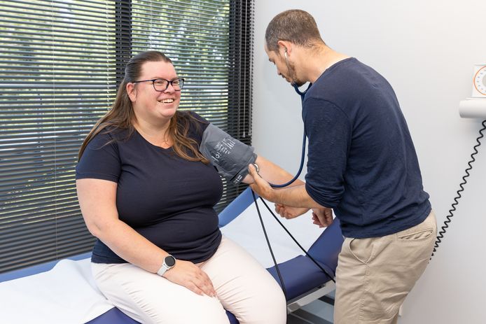 Een medewerker van de Nederlandse Obesitas Kliniek onderzoekt een patiënt.