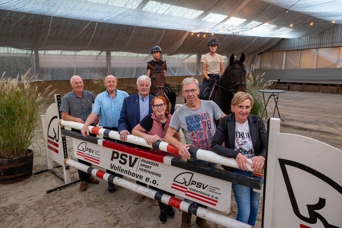 Voorzitter Theo van Diepen, de ereleden Wim Altena en Wim van Beekhuizen en de jubileumcommissieleden Titia Bos, Cees Winter en Henny Bijma (v.l.n.r.) in de manege, met op de achtergrond te paard Dennis Bijma en Kim Altena.