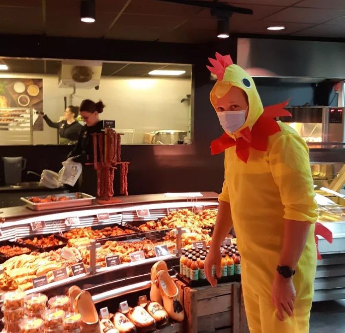 Wijkagent Frank Scheper gehuld in kippenkostuum bij zijn vaste poelier in Hardenberg.