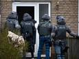 Leden van het arrestatieteam gaan de woning binnen in Middelburg-Zuid.